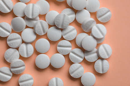 Pills on orange background, supplement and medicine concept. Closeup, selective focus, copy spaceの写真素材