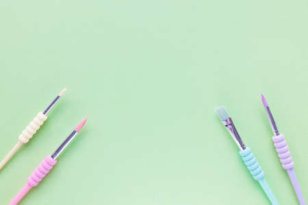 Paintbrushes for drawing, different sizes, trendy pastel colors on empty green spring background....