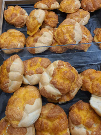 Freshly baked round czech houska buns with cheddar cheese or Kaiser rolls in bakery or grocery store
