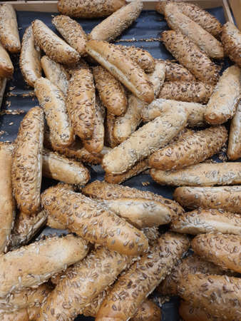 Freshly baked wholegrain Czech rohlik rolls with sunflower seeds in a bakery or grocery store. Fresh...