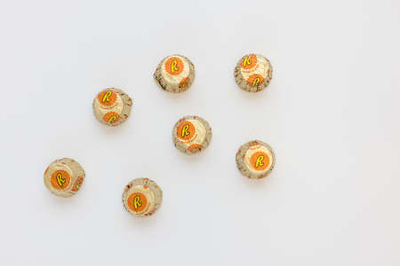 Reese miniature peanut butter cups candies on white background, copy space. Traditional American candy made of chocolate cup filled with peanut butter. Prague, Czech Republic - January 2, 2022のeditorial素材
