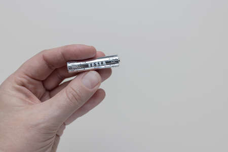 Hand holds new TESLS AAA silver plus battery, white background, copy space. Prague, Czech Republic - January 2, 2022のeditorial素材