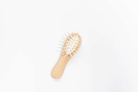 Wooden mini bamboo hair brush for travel, beard or kids on white background. Small pocket brush. Top view, copy spaceの写真素材