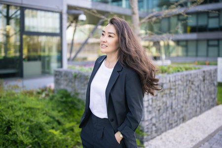 Asian confident business woman in suit. Bright future of career opportunities concept. Job, work aspirational banner, spring background of office center. Business people lifestyle. Copy spaceの写真素材