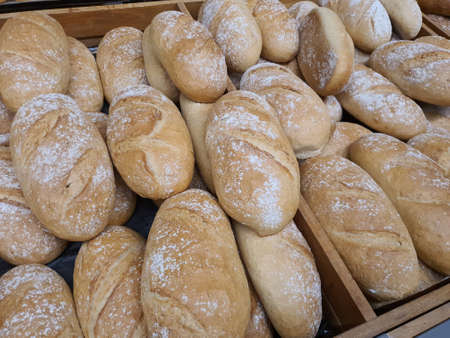 Regular bread loafs in bakery in bakery or grocery store. Freshly baked in shopping display,...