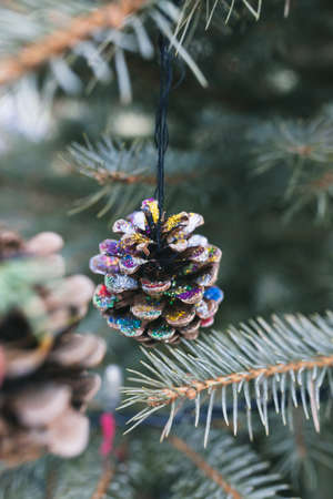 Handmade natural painted pine cone decoration on Christmas tree. Diy ideas for children. Environment, reuse, recycle, upcycling and zero waste concept. Selective focusの写真素材