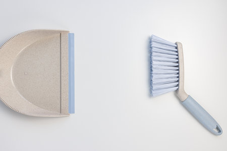 Garbage bin scoop set. Plastic gray and blue dustpan and hand brush on white background. Home cleaning, domestic chores concept. Top view, copy spaceの写真素材