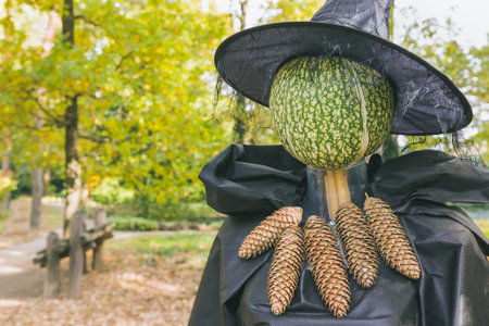 Halloween witch scarecrow with pumpkin head and hat autumn outdoor decoration. Yard decor and holiday ideas for party. Selective focus, copy spaceの写真素材