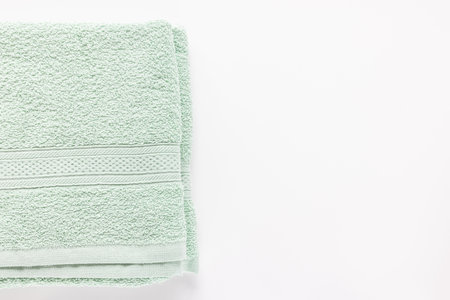 New folded mint green bath sheet or towels on white background. Top view, copy spaceの写真素材