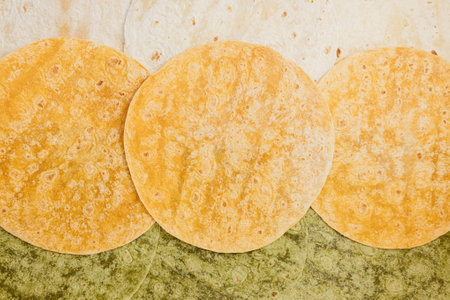 Tomato, spinach flavored and plain wheat tortilla wraps. Spanish or Mexican unleavened flatbread...