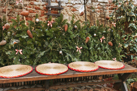 Christmas family bench in garden. Rustic boho style outdoor decor. Pine branches, pine cones and...