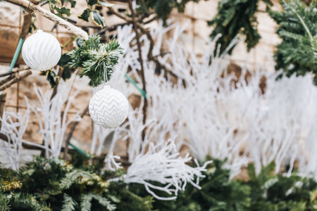 Christmas outdoor decoration on building. Pine branches and classical Christmas baubles in trendy white and silver colorsの写真素材