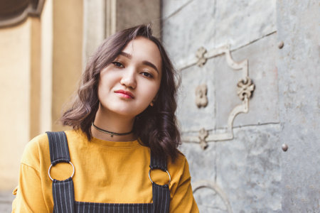 Asian young woman posing in city street. Lifestyle portrait with smile, happy faceの写真素材