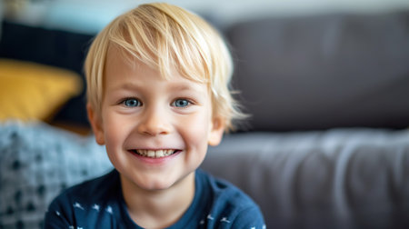 Portrait of a joyful young boy with blond hair indoorsの素材