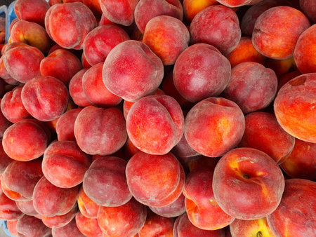 Close-up of fresh ripe peaches piled at a marketの写真素材