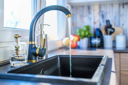 Bright modern kitchen interior with an open faucetの素材