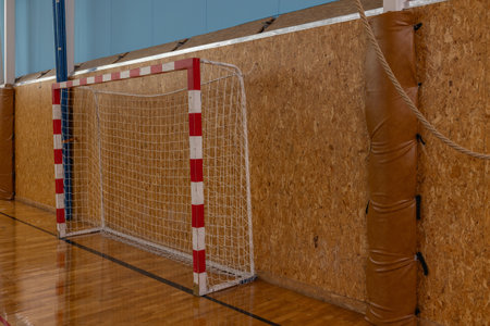 Indoor Sports Goalpost in Gymnasium with Wooden Wall, Red and White Net for Team Practices.の写真素材