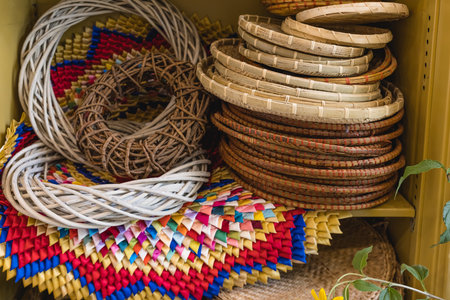 Handcrafted Woven Baskets and Mats on Shelf in Colorful Patterns.の写真素材