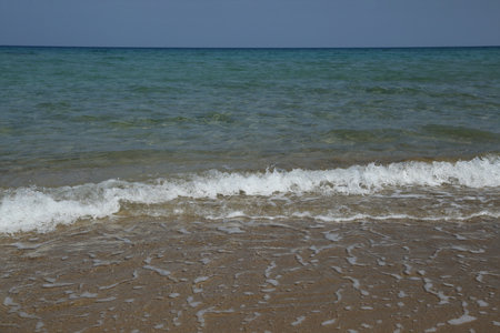 Clear ocean water gently lapping at a sandy beachの写真素材