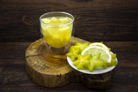 Pineapple juice and lemon with star fruit on a wooden background.の写真素材
