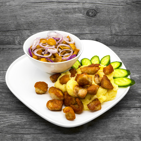 Mashed potatoes with chicken and mushrooms on a wooden backgroundの写真素材