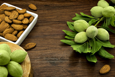Almond branches and nuts on a wooden table.の写真素材