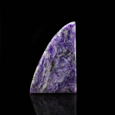 Charoite is lilac stone (Charoite Jade) from Sakha Republic, Russia, the Chara River. Charoite on a black background with reflection.の写真素材