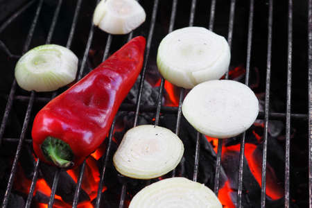 Grilled red pepper and onion are baked on  fire.の写真素材
