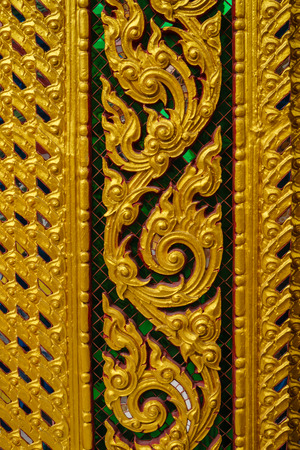 the golden thai wall sculpture, laithai at temple in thailandの写真素材