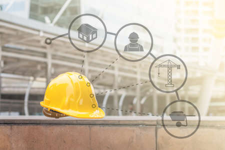 The yellow safety helmet put on the blueprint at construction siteの写真素材