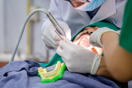 dental surgery Male dentist doing tooth extraction for male patient in dental chair Dentist examining patient's teeth in modern dental officeの写真素材