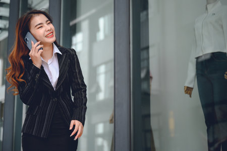 Portrait of Asian businesswoman successful smile happy Lifestyle of working Asian women Happy talking on the phone near her officeの写真素材