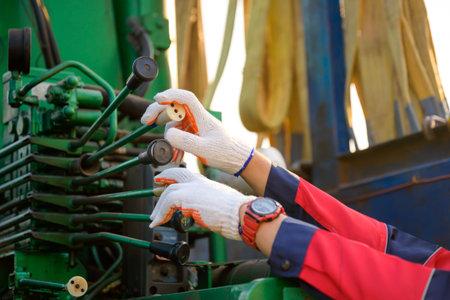 Close-up shot of a worker operating a crane at a construction site. to lift heavy construction...