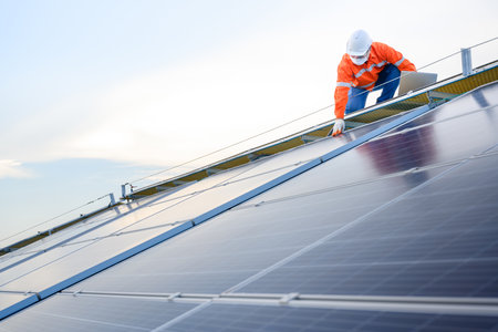 Engineers use a laptop computer to examine the solar panels at a power plant installed with solar...