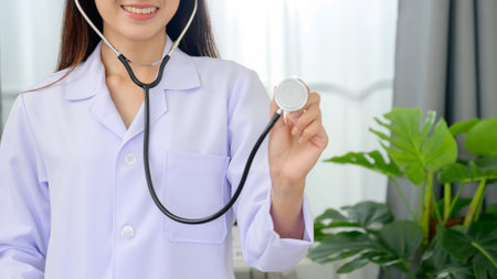 Asian female doctor holding a stethoscope Happy woman in hospital gown with stethoscopeの写真素材