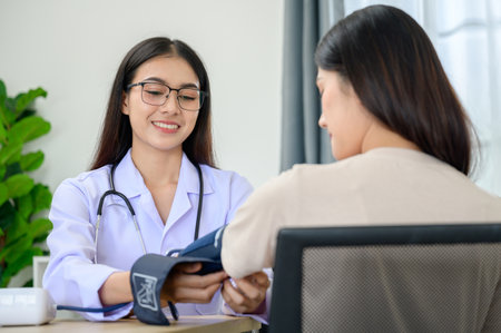 Portrait of Asian female doctor measuring heart and blood pressure while taking care of beautiful...