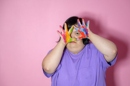 Portrait of an Asian woman with Down syndrome Acrylic and hand paint pink backgroundの写真素材