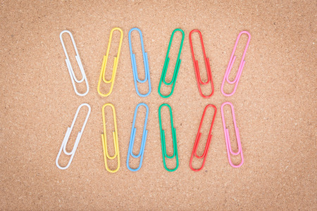 Colorful paper clip on corkboard