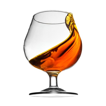 Splash of cognac in glass on white backgroundの写真素材
