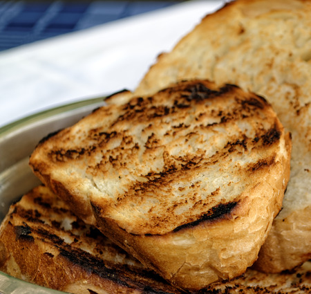 Fresh toasted sliced white bread in metal bowl on the table.