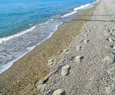 Footprints in the sand on the beach in Greece