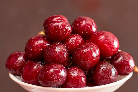 A filled bowl of cherries over white