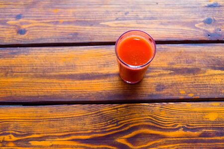 Tomato juice on a wooden table. Healthy organic food concept. Copy space