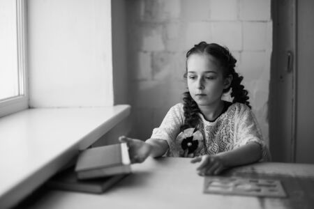Beautiful blonde schoolgirl with books in the school. Portraitの写真素材
