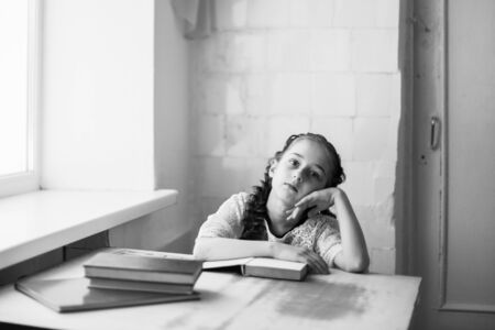Beautiful blonde schoolgirl with books in the school. Portraitの写真素材