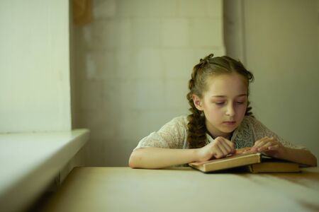 Pupil in school uniform with braids. Girl schoolgirl at school with books in school uniform....