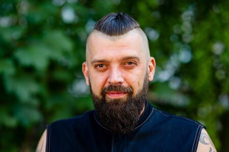 Handsome man with beard and mustache summer vacation. Brutality of concept. Summer heat season concept. Nature. Man bearded hipster bright foliage background. Guy relax in summer forest.の写真素材