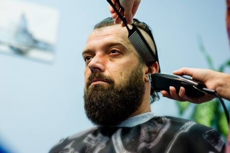 Hipster client visiting barber shop. Mens fashion. Bearded man after barber shop. Man hipster having barber shave barbershop hair machine. fashionable haircut, rear view. Weave braids.の写真素材