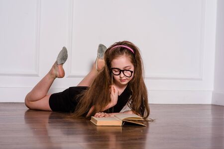 little fashion model in dress photo in photostudio backstage. A child of a girl of 8-9 years old is...