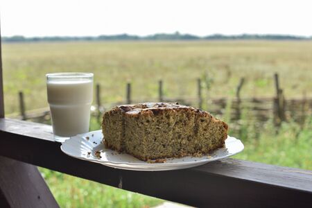 Bun with poppy seeds with a glass of milk. Milk in a glass and poppy seed cake on a field...